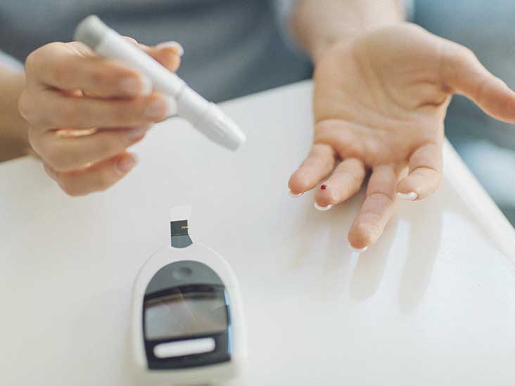 diabetes patient sticks finger to measure blood sugar level